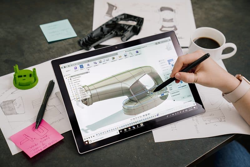 Tablet with stylus displaying a 3D CAD model on a desk setup